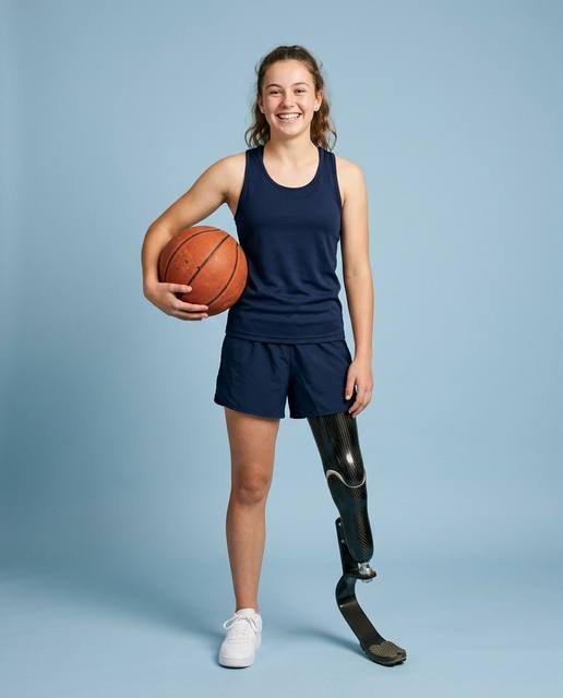 Teenage girl with a running blade holding a basketball